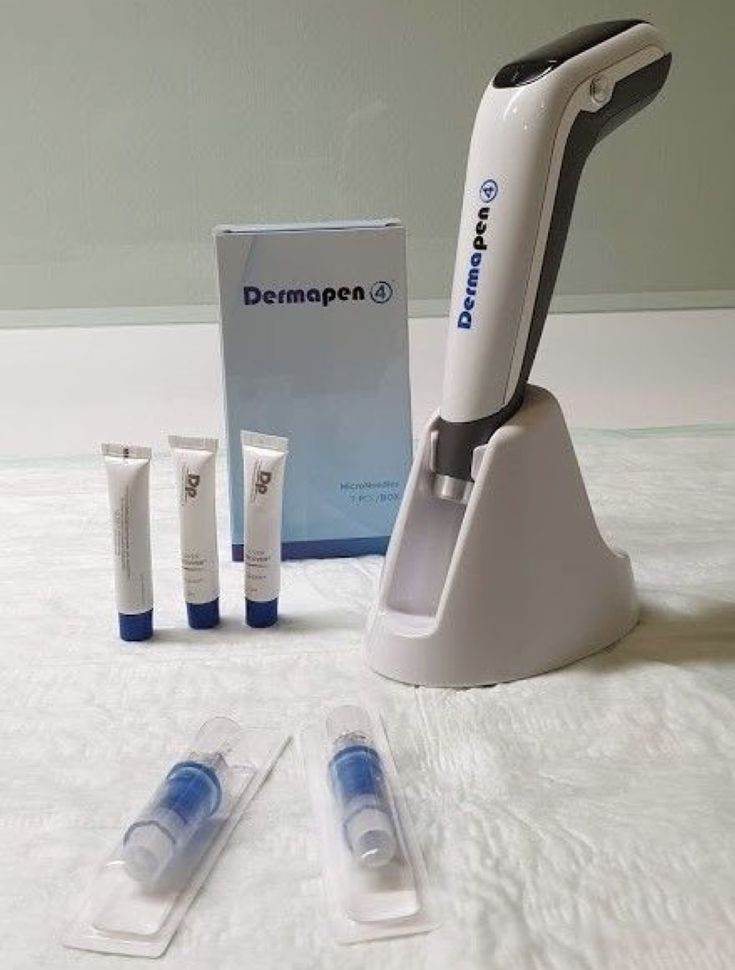Dermapen 4 device on its stand with Dp Dermaceuticals products and sterile needle cartridges